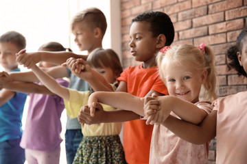 Little children holding hands together indoors. Unity concept
