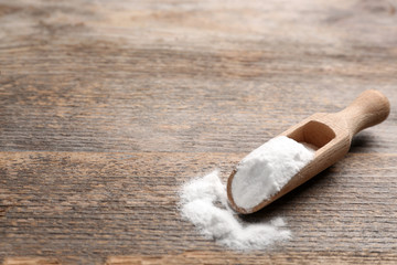 Scoop with baking soda on wooden table