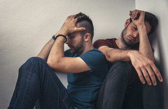 Gay couple going through rough times, comforting each other, experiencing quiet sadness