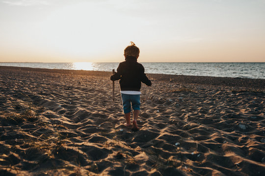 Little Boy At The Beach At Sunset