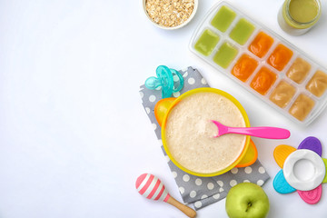 Flat lay composition with bowl of healthy baby food and space for text on white background