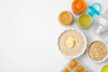 Flat lay composition with bowl of healthy baby food and space for text on white background