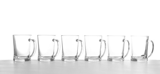 Row of empty beer mugs on white background