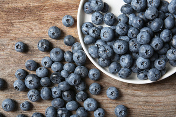 Flat lay composition with juicy and fresh blueberries on wooden table
