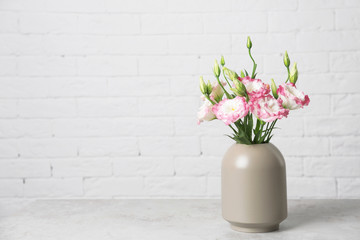 Beautiful flowers in vase and space for text on blurred background. Element of interior design