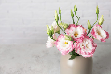 Beautiful flowers in vase as element of interior design on table. Space for text