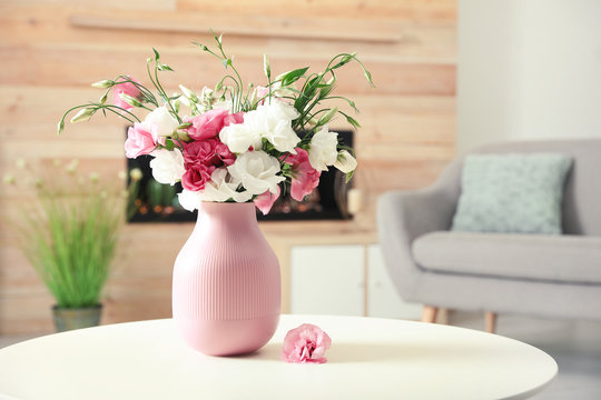 Vase with beautiful flowers on table in living room, space for text