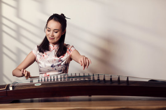 The young woman playing guzheng