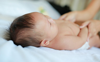 Cute infant baby boy lying on bed.