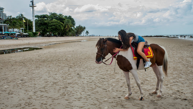 Young woman on beach riding horse Thailand - Powered by Adobe