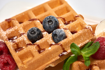 Dessert dish. Belgian waffles with ice cream, blueberries and raspberries.