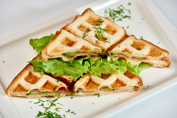 Waffle sandwich with ham and salad./Crispy sandwich with ham and salad. Breakfast.