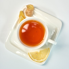 Tea with lemon and ginger./Tea in a white cup with lemon and ginger. Isolated on white background.