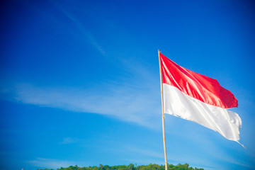 Indonesian Flag nearby the ocean in Bali, Indonesia. Bali is an Indonesian island and known as a tourist destination.