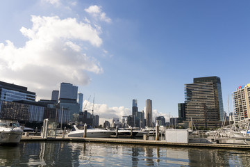 Fototapeta na wymiar Docklands, Melbourne, Victoria, Australia. Waterfront buildings and marina, water and glass sparkling in sunshine.