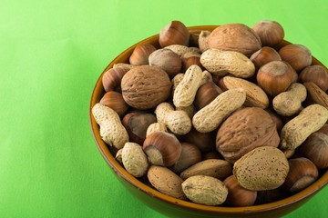 Mixed Nuts in the Bowl on Green Background