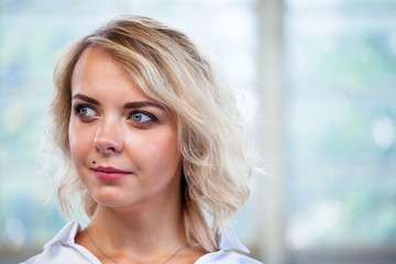 close-up portrait of a beautiful young blonde girl with a calm face and a slight smile