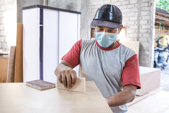 worker applying wood board layer using wood superglue