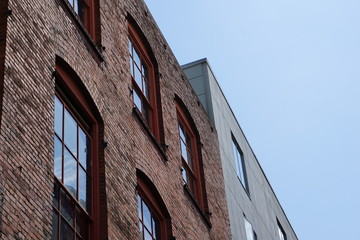 Brick and concrete building side-by-side against a grey sky