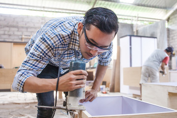 Fototapeta premium worker cutting the edge of wood board using fret saw