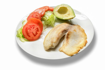 Fillet of fish served with tomato, lettuce and avocado salad.