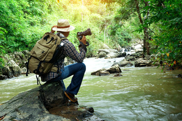 Nature photographer will take photos calm water stream around the rocks in forest