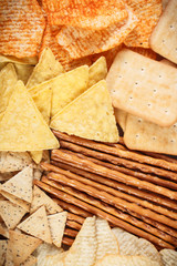 Heap of salted crisps, breadsticks and cookies, concept of unhealthy food