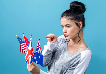 Young woman with learn English theme with the flags of English speaking countries on a blue...