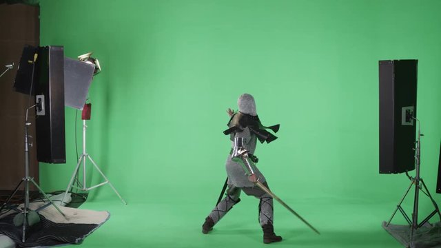 Knight in Armor battling with sword on green screen film set