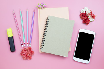 Notebook mobile phone flower rose on pink background pastel style with copyspace flatlay topview.