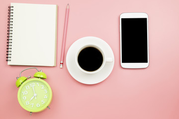 Notebook mobile phone black coffee green clock on pink background pastel style with copyspace flatlay topview.