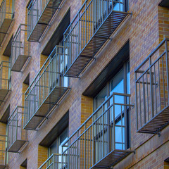 Obraz premium Narrow and airy balconies of a brick building