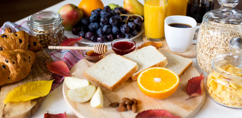 Breakfast with croissant. Orange juice in a glass bottle. Coffee in the French press. Good start to the day. Good morning.