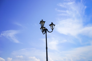 A decorated street lamp, blue sky in the background