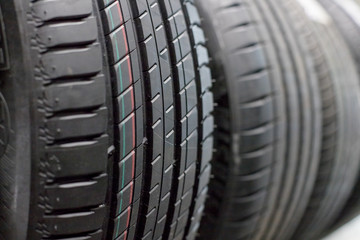 Obraz na płótnie Canvas Protector of automobile tires. A number of automobile tires. Close up view on auto mobile new wheel tire surface. Different pattern and type tires for car industry commercial transport transpotration.