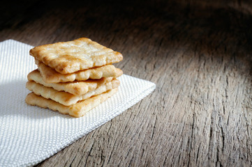 Crackers on a white sackcloth old wooden table background. Tasty crispy crackers cookies idea for children and adults. Blank copy space
