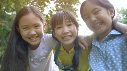 Group of little happy Asian girls playing together in the park