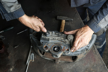 The mechanic serves the truck. Repair brake caliper. Close-up. Maintenance. Brake system. Brake spare parts. Hands working close-up.