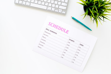 School student's schedule with time of lessons on white office desk with computer keyboard top view copy space