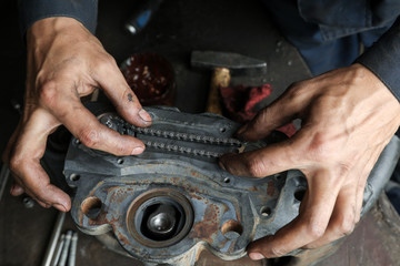 The mechanic serves the truck. Repair brake caliper. Close-up. Maintenance. Brake system. Brake spare parts. Hands working close-up.
