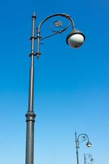 A decorated street lamp, blue sky in the background