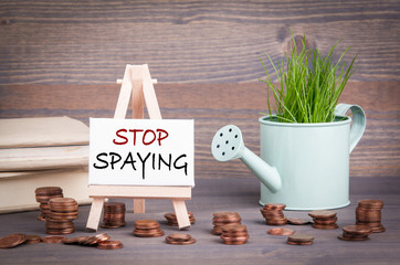Stop Spaying, policy and economic benefits concept. Miniature watering pot with fresh green spring grass and small change
