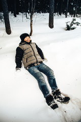 Fototapeta na wymiar Teenager boy having fun in winter forest
