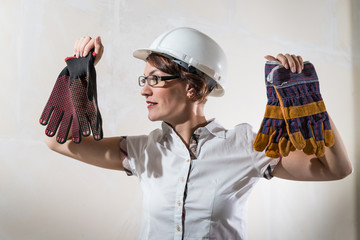 Cute young woman in white construction protection building helmet in unfinished apartment © keleny