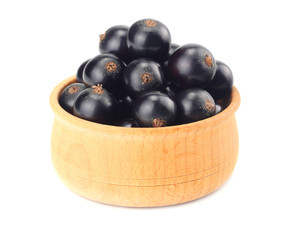 black currant in wooden bowl isolated on white background