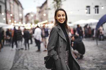 portrait of young beautiful fashionable brunette woman posing in street at autumn.