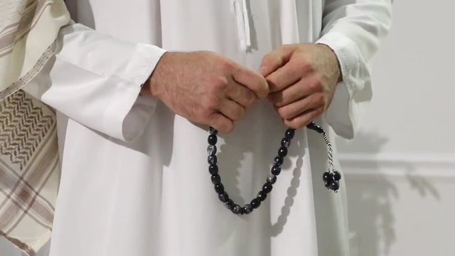 Middle easter religious man standing with subha in his hands.