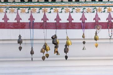 Golden bells and decorations hanging in front of a temple in the buddhist Wat Arun