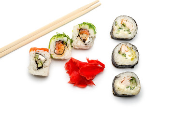 Food abstract background. On the white plane lie rolls or sushi, ginger plates and sticks for sushi.