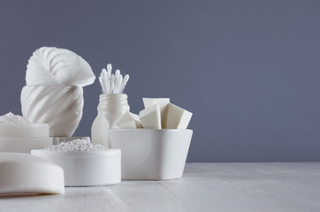 Cosmetics mockup of white products for face skin care in elegant modern grey dark bathroom interior.